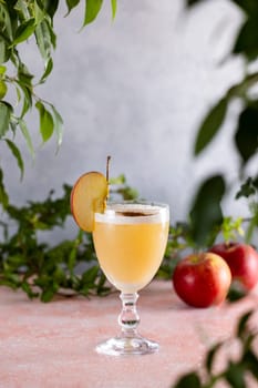 Apple cider cocktail in elegant glass, garnished with fresh apple slice and a sprinkle of cinnamon, creating a tempting autumn beverage