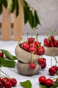 Ripe, juicy cherries spilling from stacked ceramic bowls, creating a vibrant display of freshness