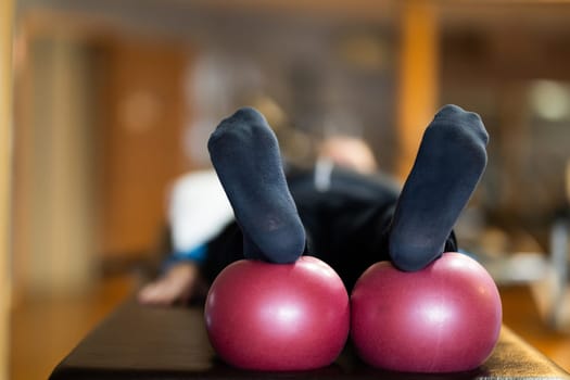 A close up shot of a patients legs resting on rehabilitation balls, aiding in recovery and improving flexibility during therapy