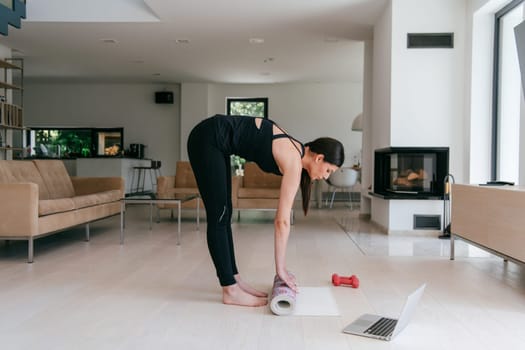 Young Beautiful Female Exercising, Stretching and Practising Yoga with Trainer via Video Call Conference in Bright Sunny House. Healthy Lifestyle, Wellbeing and Mindfulness Concept