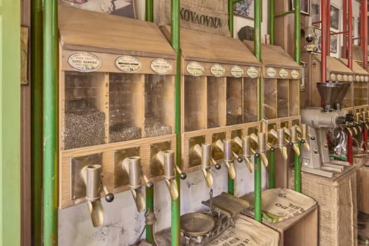 Crete.Greece - april 02, 2025: Traditional coffee dispensers filled with aromatic beans, offering a glimpse of Greek culture with neatly organized labels and a rustic wooden design.