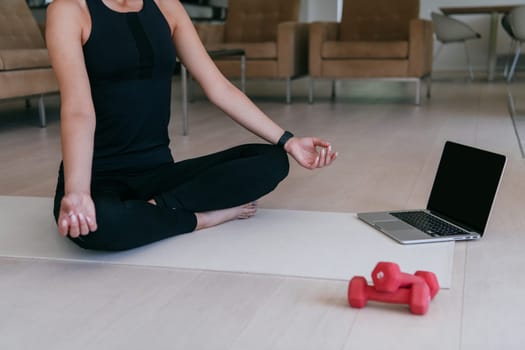 Young Beautiful Female Exercising, Stretching and Practising Yoga with Trainer via Video Call Conference in Bright Sunny House. Healthy Lifestyle, Wellbeing and Mindfulness Concept
