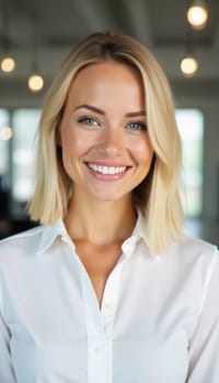 A cheerful blonde woman in a white shirt smiles warmly, showcasing excellent customer service in a contemporary bank office filled with natural light.