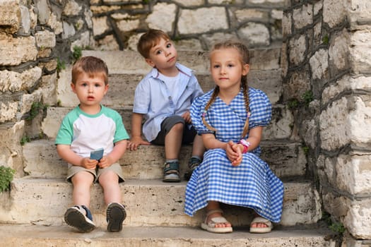 Children friends brothers and sister on the steps in the park