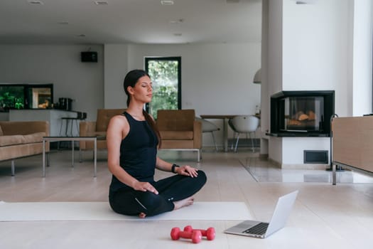 Young Beautiful Female Exercising, Stretching and Practising Yoga with Trainer via Video Call Conference in Bright Sunny House. Healthy Lifestyle, Wellbeing and Mindfulness Concept