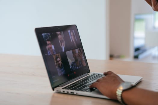 Photo of a laptop with modern headphones on a wooden table in a house with a modern interior