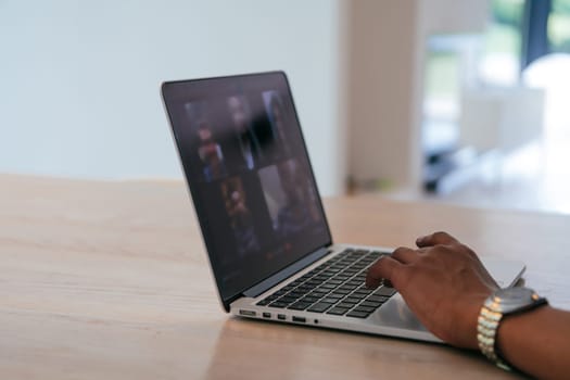 Photo of a laptop with modern headphones on a wooden table in a house with a modern interior
