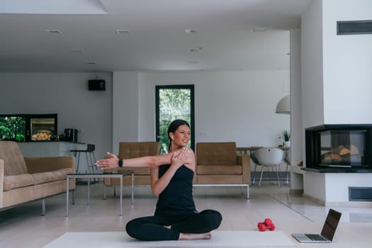 Young Beautiful Female Exercising, Stretching and Practising Yoga with Trainer via Video Call Conference in Bright Sunny House. Healthy Lifestyle, Wellbeing and Mindfulness Concept.
