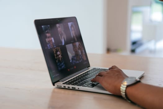 Photo of a laptop with modern headphones on a wooden table in a house with a modern interior