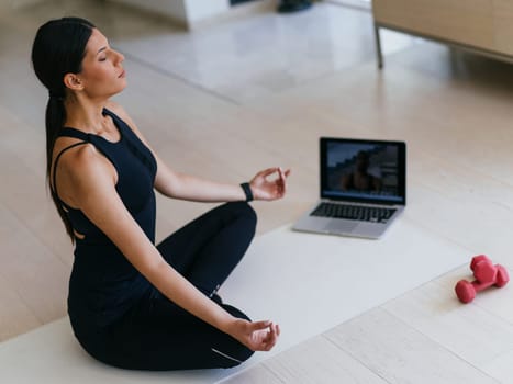 Young Beautiful Female Exercising, Stretching and Practising Yoga with Trainer via Video Call Conference in Bright Sunny House. Healthy Lifestyle, Wellbeing and Mindfulness Concept
