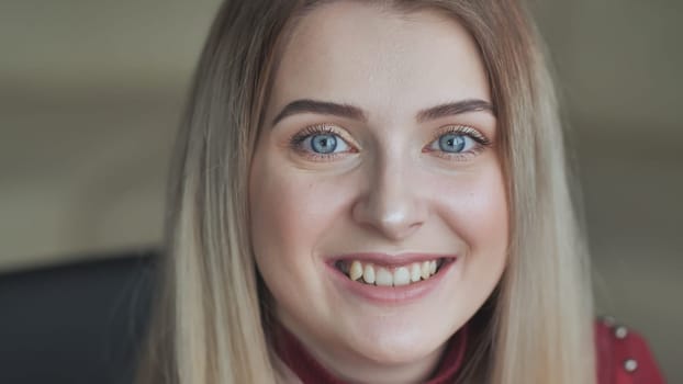 The blonde girl shows off her light makeup while smiling