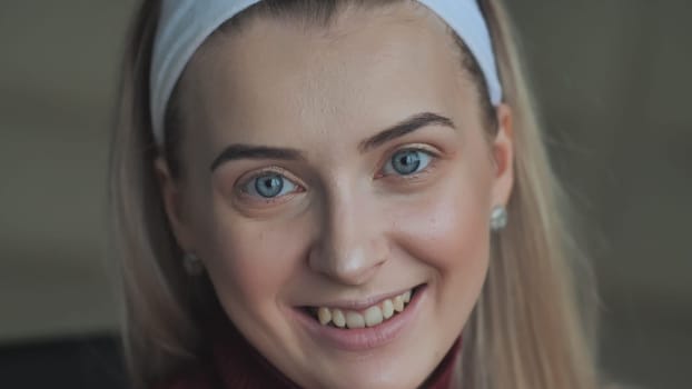 The blonde girl shows off her light makeup while smiling
