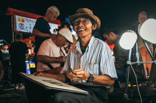 Happy asian male Vietnamese street artist paints on the street in Da Nang in Asia. Da Nang, Vietnam - November 29, 2024