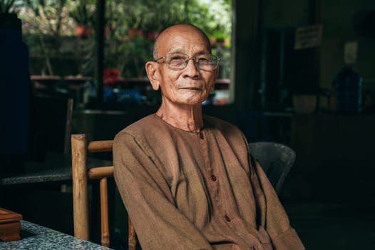 Old elderly Asian Vietnamese male monk at Buddhist Temple at the Nghia Son Pagoda in Nha Trang. Nha Trang, Vietnam - December 20, 2024