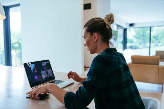 A woman sitting in the living room using a laptop is looking at cam talk by video call with business friends and relatives. The headshot is Job interview answering questions.