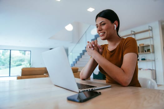 Woman sitting in living room using laptop looking at cam talk by video call with business friend relatives, head shot. Job interview answering questions