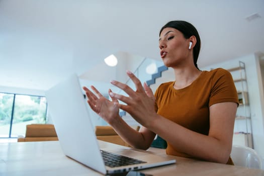 Woman sitting in living room using laptop looking at cam talk by video call with business friend relatives, head shot. Job interview answering questions