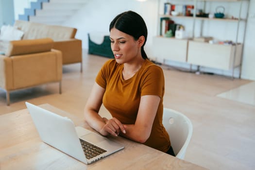 Woman sitting in living room using laptop looking at cam talk by video call with business friend relatives, head shot. Job interview answering questions