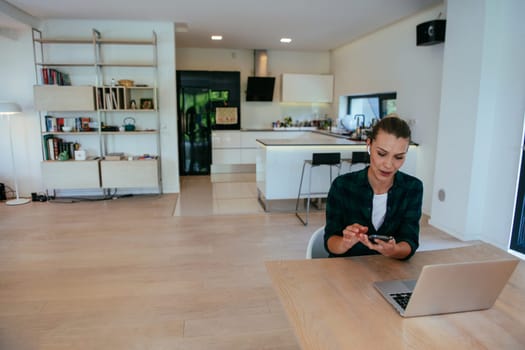 A woman sitting in the living room using a laptop is looking at cam talk by video call with business friends and relatives. The headshot is Job interview answering questions.