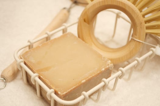 Handcrafted soap accompanied by bamboo tools on a textured surface.