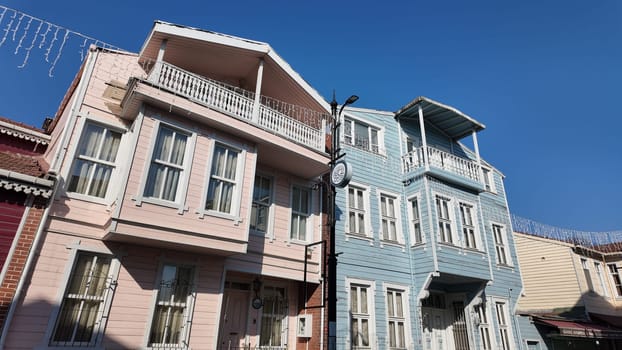 Historic wooden houses stand side by side in a vibrant neighborhood.