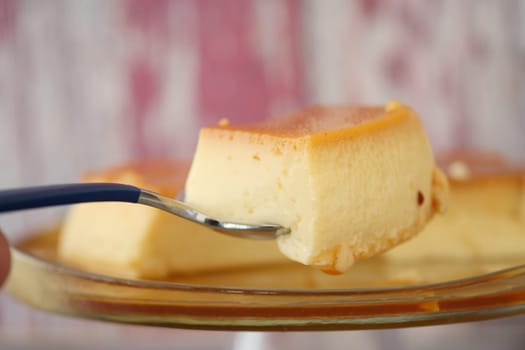 spoon pick a slice of caramel pudding ,