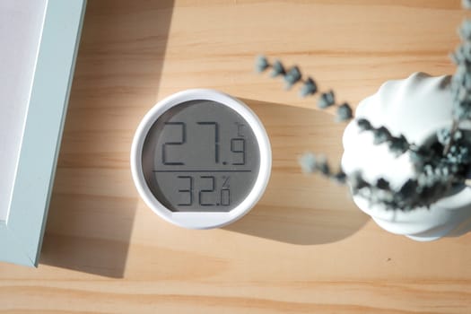 Digital thermometer shows current temperature and humidity in a room.