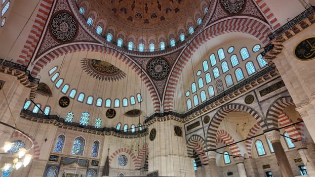 Decorated mosque interior showcases intricate arches and stained glass.