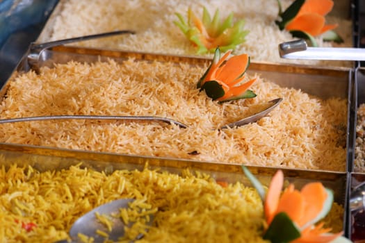 Vibrant rice dishes arranged with decorative garnishes at a market.