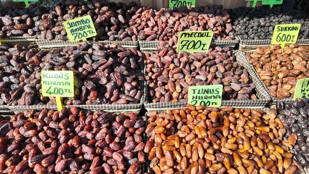 Colorful trays filled with different types of dates at a local market.