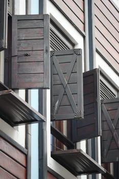 Wooden shutters are opened on the upper levels of a charming building.