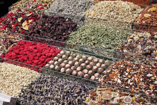 Rows of vibrant dried herbs and flowers fill market stalls with color.