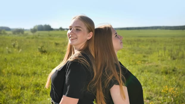 Portrait of two twin sisters in the field on a warm summer day.