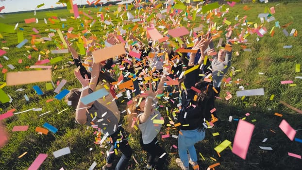 A group of friendly friends toss up candy at sunset in a field