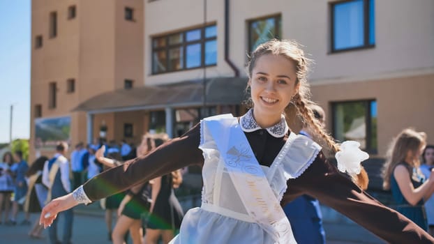Happy Russian girl graduate with pigtails on the day of graduation