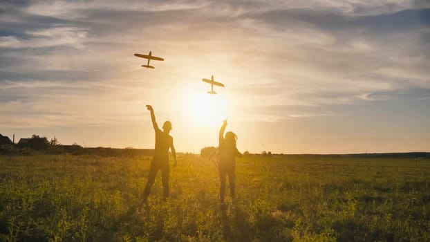 A guy and a girl launch a paralon plane at sunset