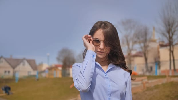 Beautiful 17 year old girl posing outdoors against the blue sky