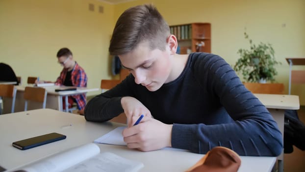 Schoolchild in class busy with work. Russian school
