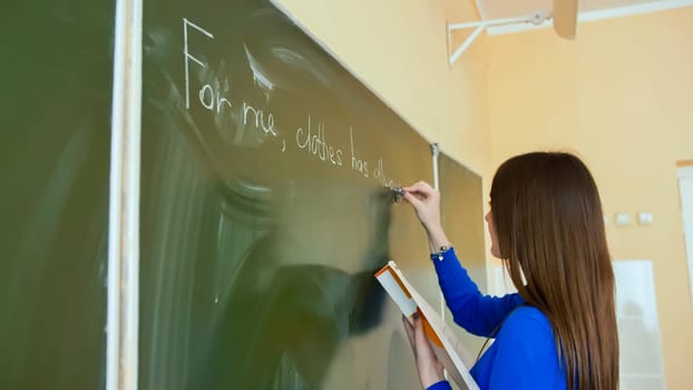 A girl writes on a school board during an English lesson