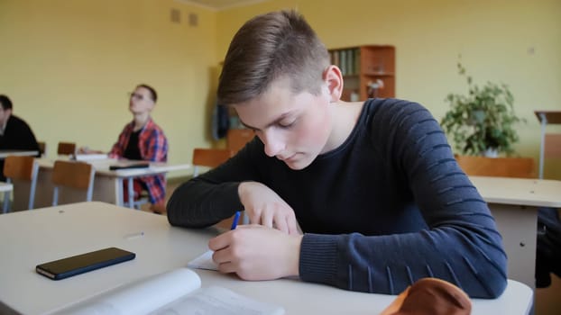 Schoolchild in class busy with work. Russian school