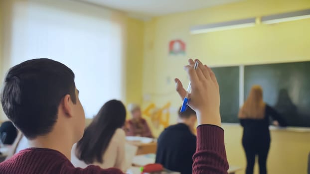 High school student raises his hand during the lesson