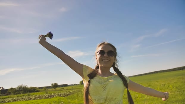 Young 17 year old girl with a cornflower flower outside the city on a summer day