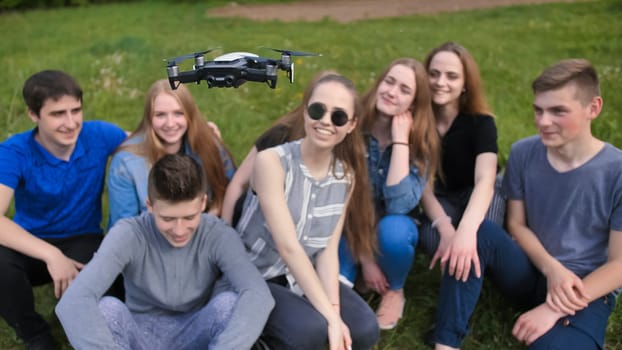 Cheerful friends are watching the flight of the drone