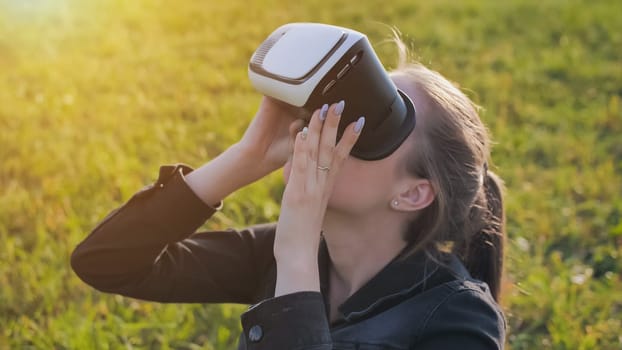 Young girl in virtual glasses in a city park