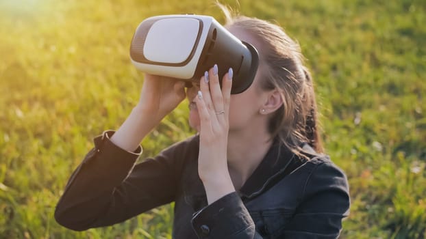Young girl in virtual glasses in a city park