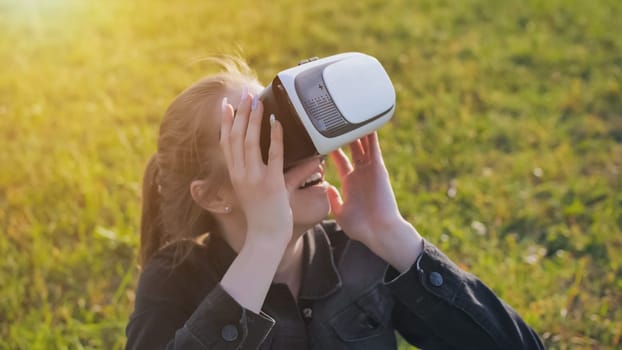 Young girl in virtual glasses in a city park