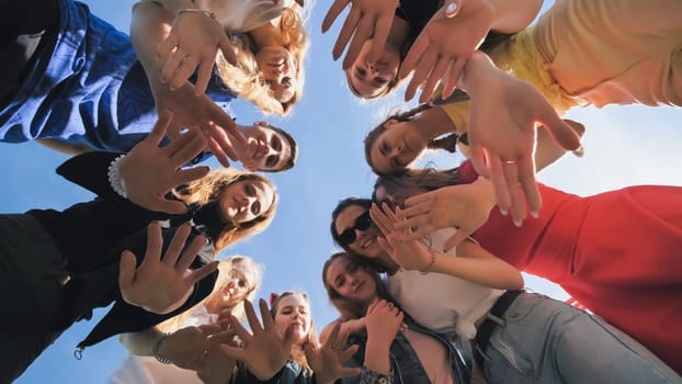 Happy friends connected in a ring together. View from the bottom. The concept of strong friendship