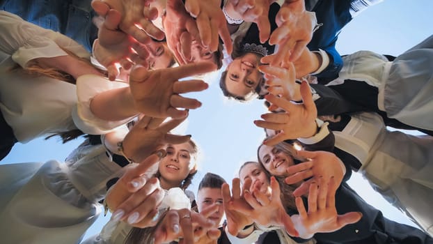 Happy friends connected in a ring together. View from the bottom. The concept of strong friendship