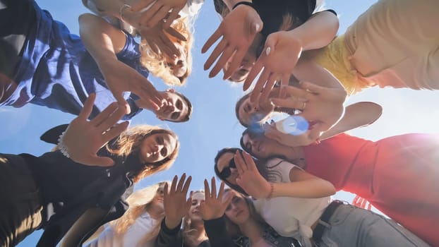 Happy friends connected in a ring together. View from the bottom. The concept of strong friendship