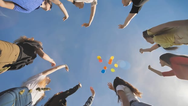 A group of friends release colorful balloons into the sky